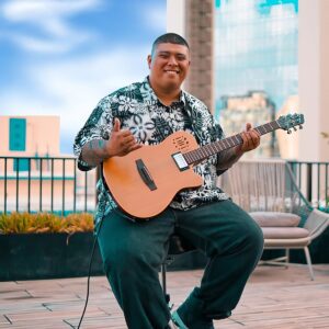 sitting holding guitar
